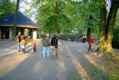 Kinder und Erwachsenen treffen sich in der Parkanlage.