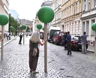 Menschen auf einer Straße halten künstliche Bäume
