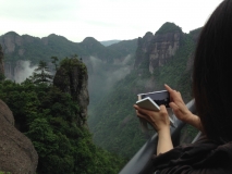 Touristin, die ein Foto von der Landschaft in Xianju, einem Pilotnationalpark Chinas, macht