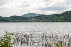 Der Laacher See, eine  wassergefüllte Caldera, mit der Klosteranlage Maria Laach auf der gegenüberliegenden Seite des Kratersees.