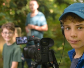 Junge Menschen mit Filmausrüstung im Wald