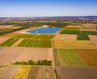 Luftaufnahme einer Kulturlandschaft in Deutschland mit Feldern und einem See